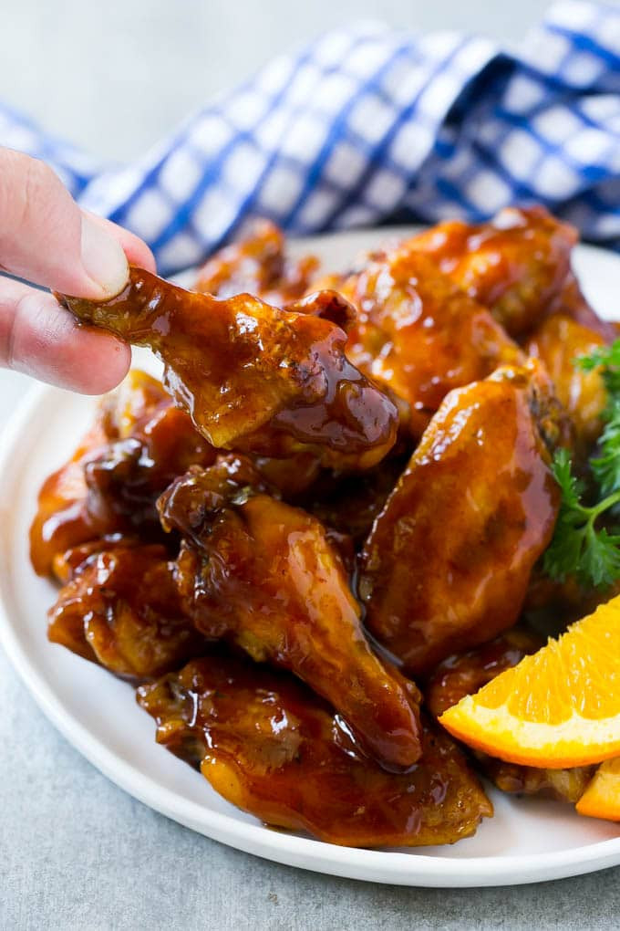 Slow Cooker Chicken Wings Food Network
 A plate of slow cooker barbecue chicken wings with a hand